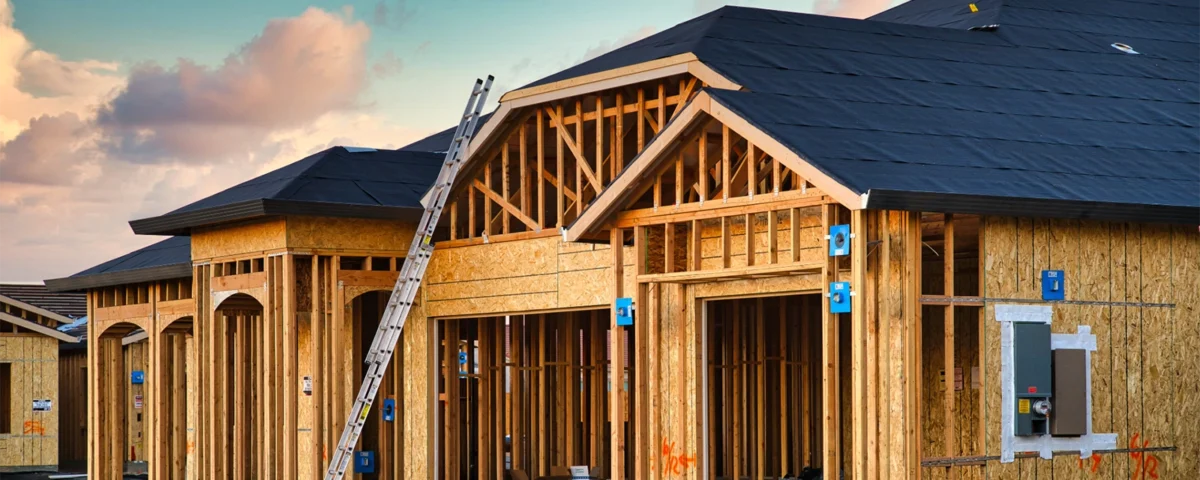 How to Build a House — wood wall framing and roof trusses going up